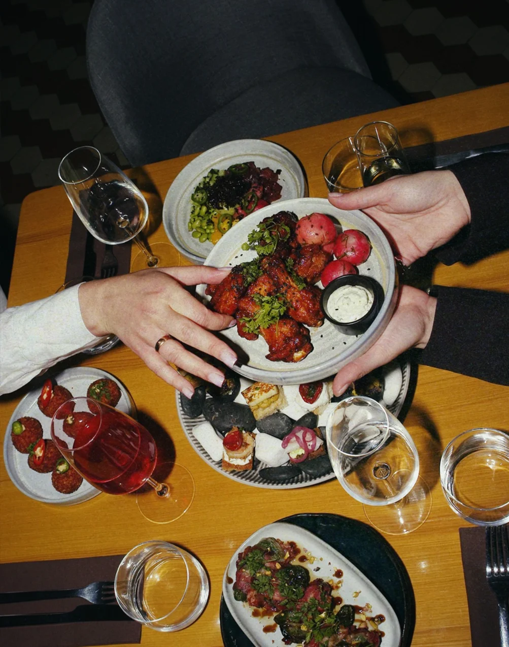 Guests passing plates across a wooden table