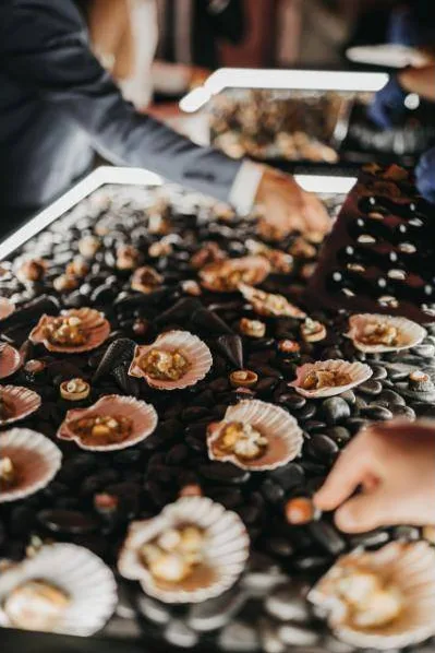 Scallops in their shells on a lit stone table